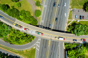 Vehicles navigate multi lane road with lush trees lining edges in bustling suburban American town...
