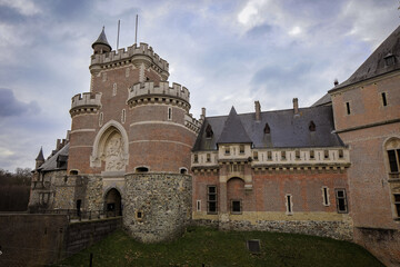 Fototapeta premium Haasbeck Castle in Belgium showcases impressive architecture with intricate brick patterns and historic significance in a scenic landscape
