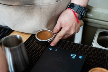 barista prepares coffee using portafilter, focusing on precision and technique. scene captures essence of coffee making with attention to detail and craftsmanship