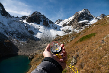 Mountain range and tourist hand with compass on foreground. Nature reserve, travel concept....