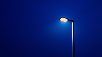 A monochrome streetlight against a deep blue night
