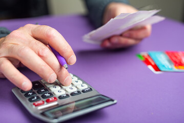 man doing calculations on a calculator to file a tax return.