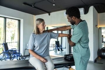 Obraz premium Tall african american doctor working on correction the female patients posture