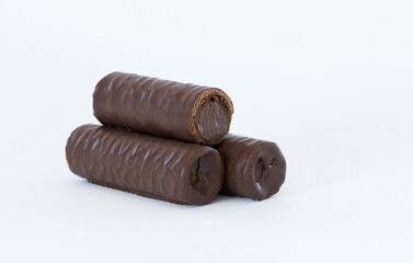 Sweet chocolate covered rolls - table arrangement, isolated on white background. Selective focus. Copy space.