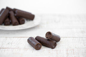 Sweet chocolate covered rolls - table arrangement, isolated on white background. Selective focus. Copy space.