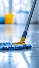 A person is mopping a clean and reflective tiled floor