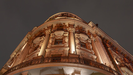A historic building with columns in Moscow at night. A view from below of an old building with...