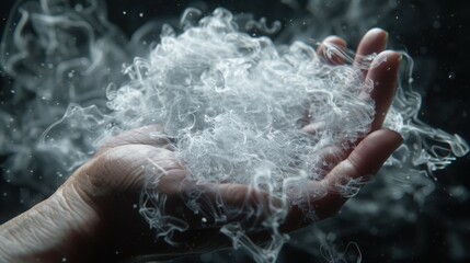 Obraz premium Ethereal Smoke Swirls Captured in a Hand Against Dark Background