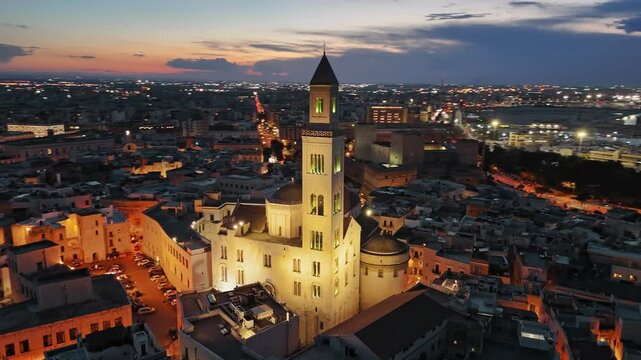 Evening sunset view of Cathedral of San Sabino in old town of Bari. Aerial shot of Bari, Puglia, Italy. City ligths and red sunset sky