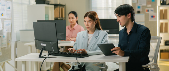 Learning, computer and training business interns in modern office. Customer service job, Cheerful asian business woman discussing project results with colleagues working together, software developers
