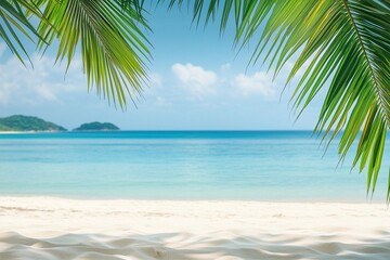 Tropical beach background with palm leaves and sand, a banner for a summer vacation concept. Shallow depth of field with blurred seawater in the foreground and an island on the horizon. Bright, sunny 