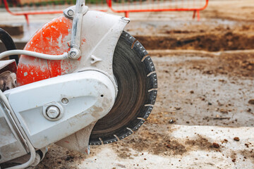 Close-up of Concrete cutting saw in action at a construction site during midday, showing precise...