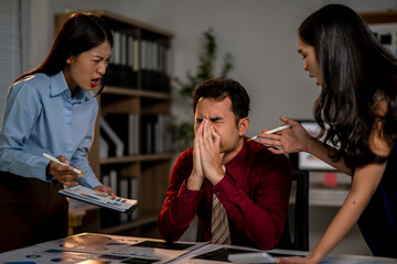 Three people are in a room, one of them is holding a pen