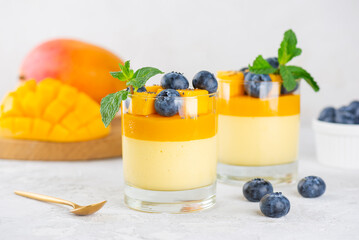 Italian panna cotta dessert of coconut cream thickened with agar agar with layer of mango served in...