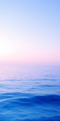 Obraz premium A tranquil ocean view with soft blue hues and a calming horizon, creating a serene and peaceful background ideal for a mobile wallpaper. 