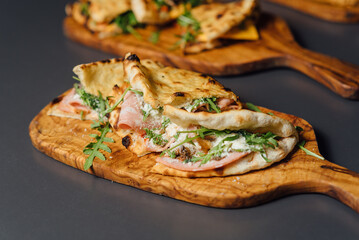 Close up of Pizza-Sandwich with Mortadella and Roasted Eggplant – A gourmet Italian creation featuring mortadella sausage, roasted eggplant, parmesan cheese, mozzarella, truffle paste, and arugula 
