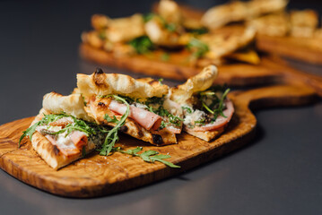 Pizza-Sandwich with Mortadella and Roasted Eggplant – vertical composition with Pizza Sandwiches Served on Wooden Platters in a Rustic Setting