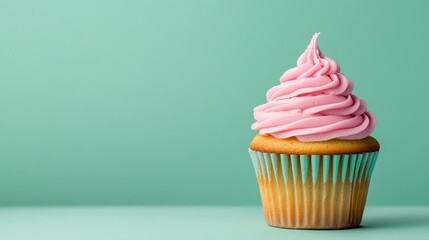 Single Vanilla Cupcake with Pink Frosting on Mint Green Background