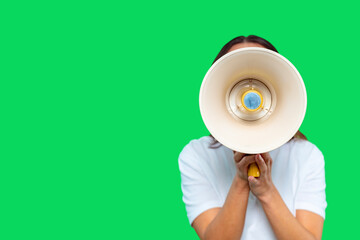 Individual holding a megaphone in front of a bright green background while appearing engaged in a...