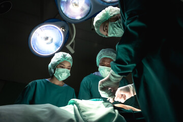 Professional males and female medical team concentrating perform critical surgical operations in...