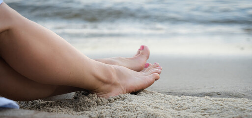 Woman's beautiful legs on the beach