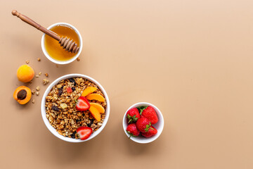 Bowl of cereal granola with strawberry and honey for breakfast, top view