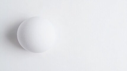 Minimalistic composition featuring white sphere against light ba