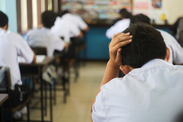 Students are so stressed they hold their heads during exams.