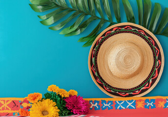 Vibrant sombrero hat with colorful flowers against blue wall, perfect for festive celebrations