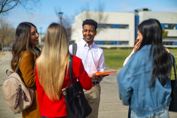 University teacher talking and laughing with students on campus