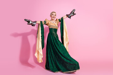 Fototapeta premium Royal-themed portrait with pink background highlighting a woman in medieval costume and knight gloves, blending grace with strength