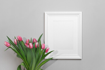 Blank portrait picture or photo frame mockup with fresh tulips flowers bouquet, white mock up with copy space