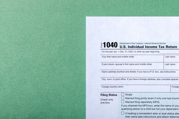 Individual income tax return form 1040 on green background with copy space. Tax time concept