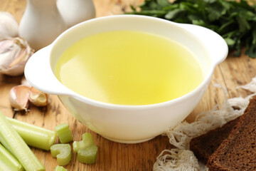 Tasty chicken bouillon served on wooden table, closeup