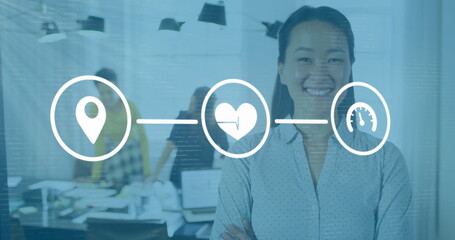 Image of media icons over asian businesswoman smiling in office