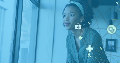 Image of media icons over biracial businesswoman smiling in office