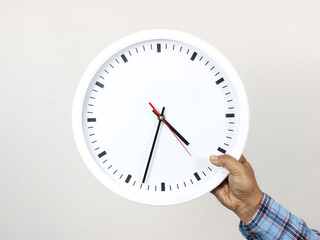 Hand holding a wall clock - on white background. Ideal for illustrating time management, reminders,...