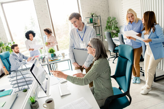 Diverse team collaborating in a modern office environment with professional attire and a focus on teamwork