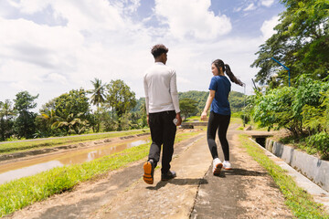 Obraz premium back view of active asian couple walking exercise at rural area