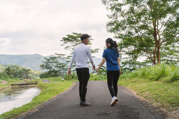 Obraz premium back view of active asian couple walking exercise at rural area