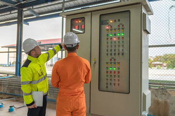 Electrical engineer man checking voltage at the Power Distribution Cabinet,preventive maintenance...