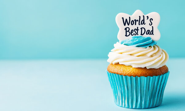 Cupcake with world's best dad topper on blue background. Banner with space for text. Sweet gift for Father's day and birthday. Concept for father's day celebration, birthday, appreciation. 