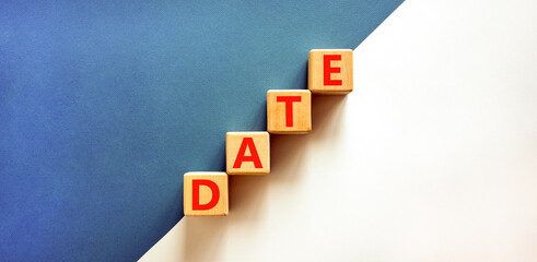 Date symbol. Concept word Date on beautiful wooden blocks. Beautiful white and blue background....