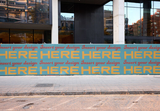 metal fence stands by a construction site near an office building in Barcelona,, Spain