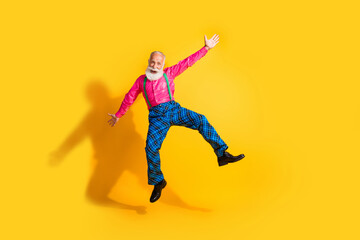 Fototapeta na wymiar Full body photo of bearded gentleman jump dancing have fun wear fashionable clothes suspenders isolated on vibrant yellow color background