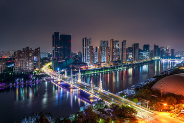 Fototapeta premium The urban river in Tongzhou, Beijing, China, and the high-rise buildings on both sides of the river under the night view