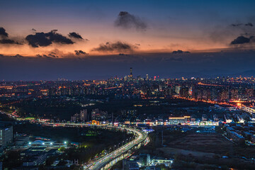 A panoramic view of the brightly lit urban night scene in Beijing, China under the twilight