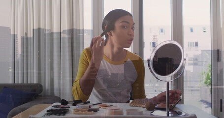 Applying makeup at vanity, person over cityscape image
