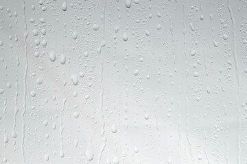 Water drops on light glass surface, top view