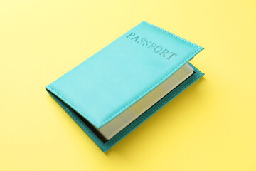Passport in bright cover on yellow background, closeup